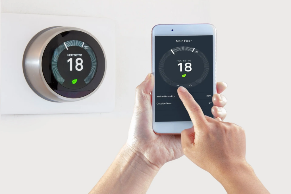 Homeowner adjusting smart thermostat from their smart phone